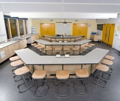 an empty classroom with many desks and chairs in it's center area,