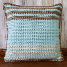 a crocheted pillow sitting on top of a wooden table