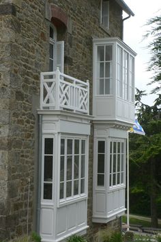 an old stone building with white windows and balconies