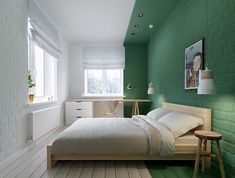 a bed room with a neatly made bed and green walls