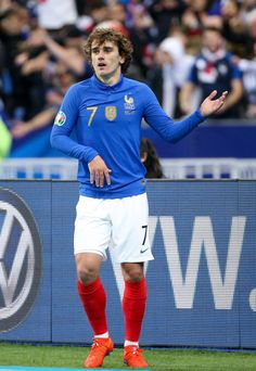 a soccer player is standing on the field with his hands out in front of him