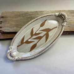 a white and brown dish sitting on top of a piece of wood