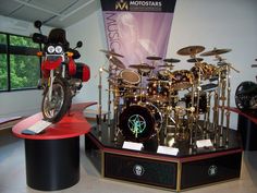 a motorcycle is on display in front of a drum set and other musical instrument items