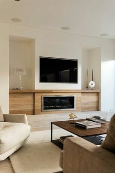 a living room filled with furniture and a flat screen tv mounted on the wall above a fireplace