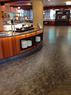 the inside of a restaurant with wood flooring and counter tops, as well as an open kitchen