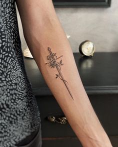 a woman's arm with a tattoo on it and a cross in the middle