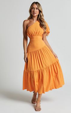 Get ready to turn heads in the Ciara Midi Dress! This one-shoulder short puff sleeve dress is a must-have for your summer wardrobe. In a vibrant mango color, this A-line dress adds a pop of fun and energy to any occasion. Made from textured woven polyester, it's lightweight and comfortable, perfect for those casual days out or dressed up for special events. The tiered design adds extra flair and movement to your look, while the midi length keeps it chic and sophisticated. Whether you're hitting