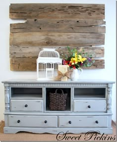 a birdcage sitting on top of a gray dresser