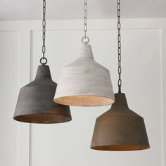 three pendant lights hanging from chains in a room