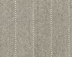 an upholstered fabric textured with white and grey dots on a gray background