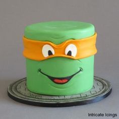 there is a green cake with a yellow mask on it's face and eyes