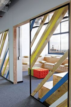 an office with colorful wooden stairs and windows