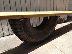 an old tire sitting on top of a wooden bench