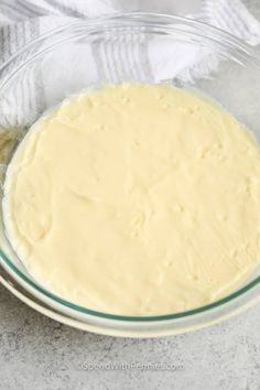 a bowl filled with batter sitting on top of a counter next to a white towel