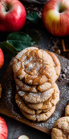 apple cider cookies stacked on top of each other with apples in the back ground