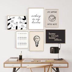 a desk with some pictures on the wall above it and a lamp next to it