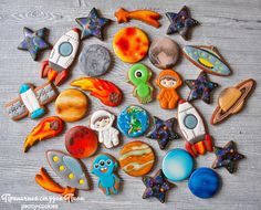 an assortment of space themed cookies sitting on top of a wooden table next to each other