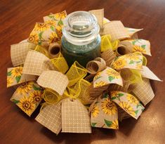 a wreath made out of burlocks and fabric with a mason jar in the center