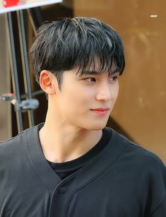 a young man with black hair is looking at the camera