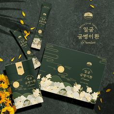 three envelopes with flowers on them sitting next to some yellow and white petals in front of a black background