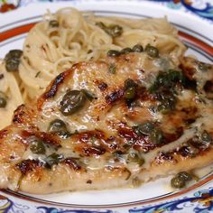 a close up of a plate of food with meat and pasta on it, including peas