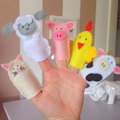 hand with five finger puppets made to look like farm animals