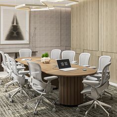 a conference table with chairs around it and a laptop computer on the desk in front of it