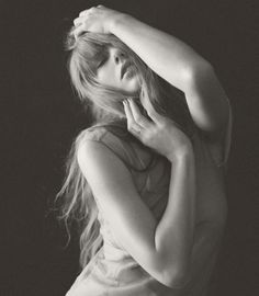 a black and white photo of a woman with her hair blowing in the wind,