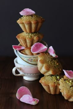 some cupcakes with pink flowers on them are stacked up in a stack and ready to be eaten