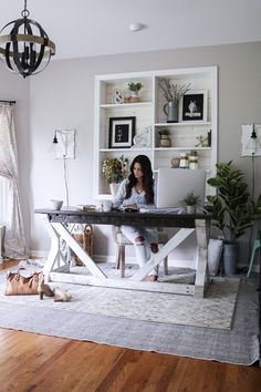 a woman sitting at a desk in her living room