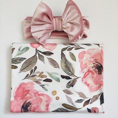 a pink flowered purse with a bow on it's head and a white background