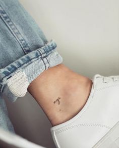 a woman's ankle with a small anchor tattoo on her left side ribcage