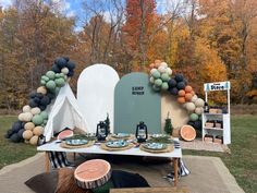 a table set up with plates and desserts for an outdoor party in the fall