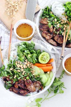 two bowls filled with meat and vegetables next to chopsticks