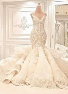 a wedding dress on display in front of a mirror