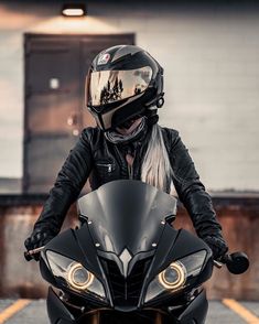 a woman wearing a helmet is sitting on a motorcycle