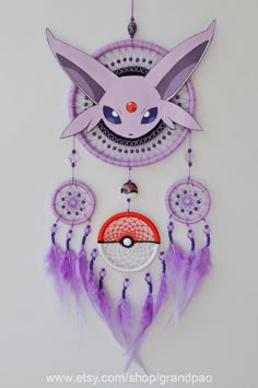 a pink and purple dream catcher with a pikachu face