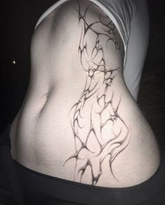 a woman's lower back tattoo is shown in black and white