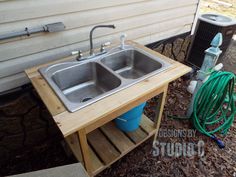 an outdoor sink with two faucets and a hose attached to the outside wall