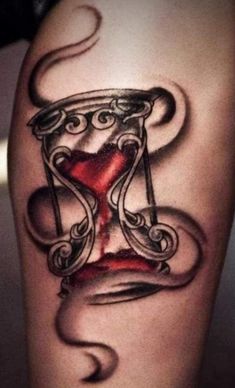 a tattoo with an hourglass on the leg and a red liquid pouring out of it