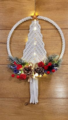 a christmas ornament hanging on a wall with pine cones and other holiday decorations