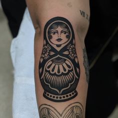 a woman's arm with a black and white tattoo design on the left forearm