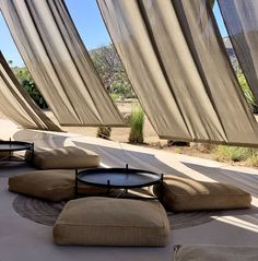 the sun is shining on some outdoor furniture and drapes in front of an open window