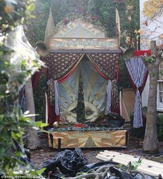 an elaborately decorated gazebo in the middle of a yard with trees and bushes