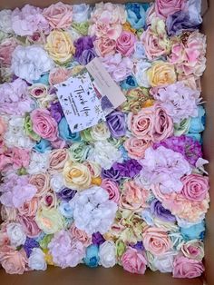 a cardboard box filled with lots of different colored flowers and a price tag on it