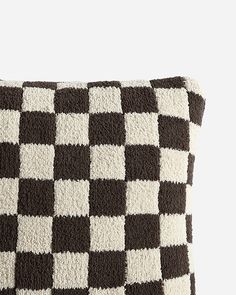 a black and white checkered pillow on a gray background