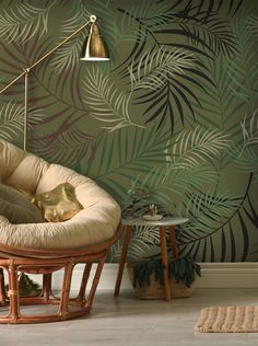 a chair and table in front of a wall with palm leaves on it