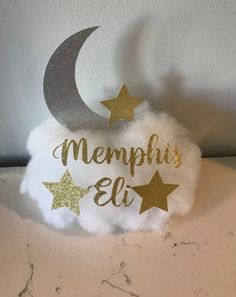 a white cloud with gold stars and the words memphi's elf on it