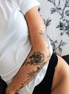 a woman with a flower tattoo on her arm