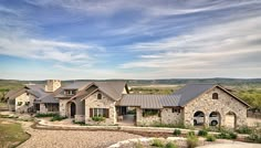 a large stone house in the middle of a field